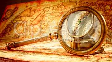 Vintage magnifying glass lies on an ancient world map