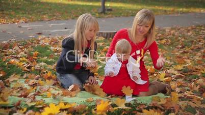 Mom and Two Daughters in Autumn Park