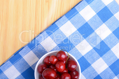 Red ripe cherries in a white bowl