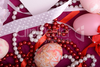 Painted Easter eggs decorated with flowers with pearls in a basket on an old table