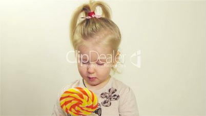 Little girl eating candy on a stick