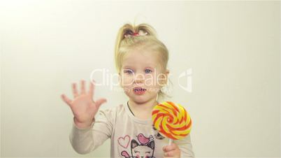 Little girl eating candy on a stick