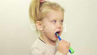 Cute little girl brushing her teeth at home