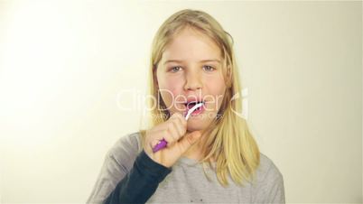 beautiful blonde girl brushing her teeth