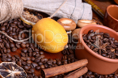 orange and lemon, coffee beans and cinnamon on wooden brown background.
