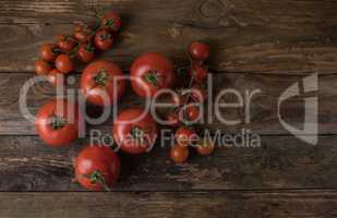 Fresh, ripe tomatoes on an old wooden board.tomatoes and small t