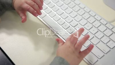 Little kid typing on keyboard