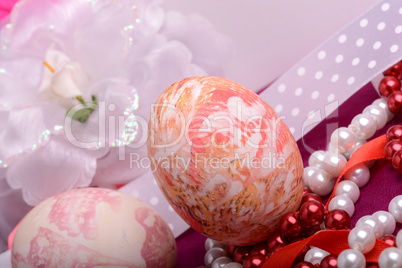 Painted Easter eggs decorated with flowers with pearls in a basket on an old table