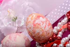 Painted Easter eggs decorated with flowers with pearls in a basket on an old table