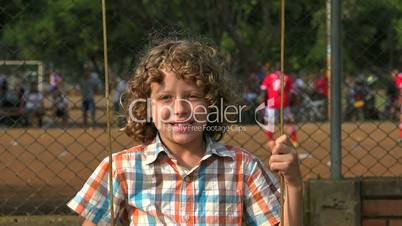 Boy Swinging At Playground