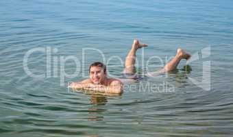 Man floating in the Dead Sea, Jordan