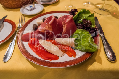 Plate of antepasto including ham and peppers