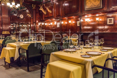 Tables laid for guests at wood-panelled restaurant