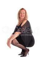 Happy woman crouching on floor.