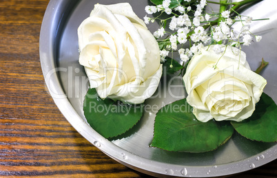 Beautiful rose on the surface of the vessel with water.