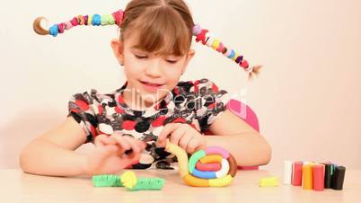 happy little girl play with plasticine