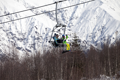 Skiers family on chair-lift at nice sunny day