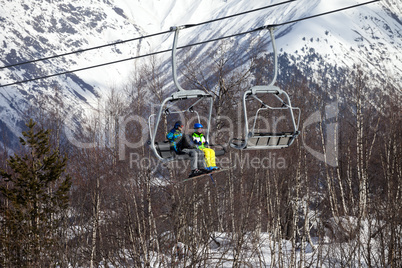 Father and daughter on chair-lift at nice sunny day