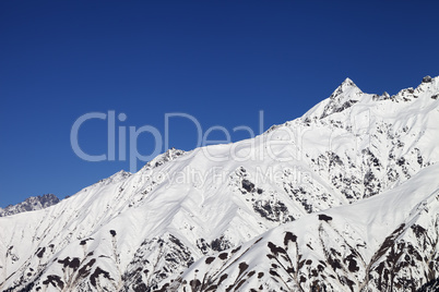 Snowy mountain peaks and blue clear sky