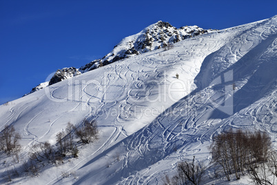 Off-piste slope with track from ski and snowboard on sunny day