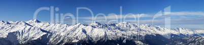 Large panoramic view on snowy mountains in sunny day