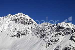 Snowy mountains and blue clear sky at cold sun day