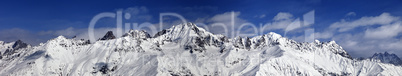 Large panoramic view on snowy mountains in sunny day