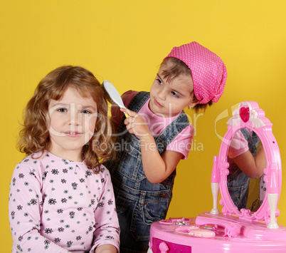 two little girls playing hairdressers