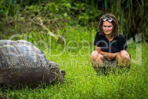 Woman staring intensely at Galapagos giant tortoise