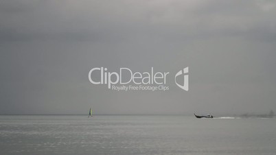 sailing and longtail boat on a clean horizon