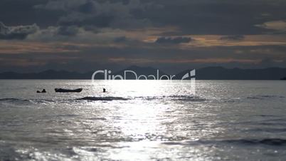 people swim near the boat into the sea