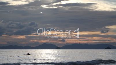 people floating around in the sea at sunset