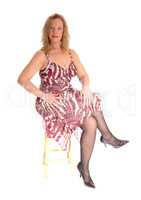Blond woman sitting on chair.