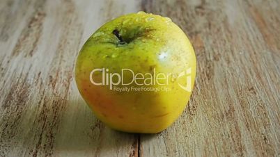 Apple rotating on a wooden Board
