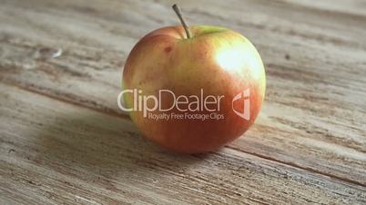 Apple rotating on a wooden Board
