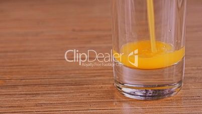 orange juice being poured into glass