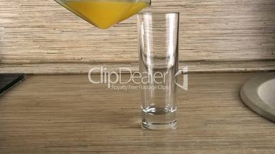 orange juice being poured into glass