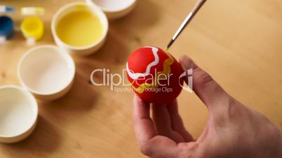 Easter, Holidays, Tradition and People Concept - close up of Woman Hands Coloring Easter Eggs with Colors and Brush