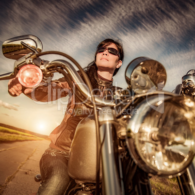 Biker girl sitting on motorcycle