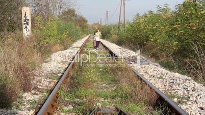 little girl walking on railroad