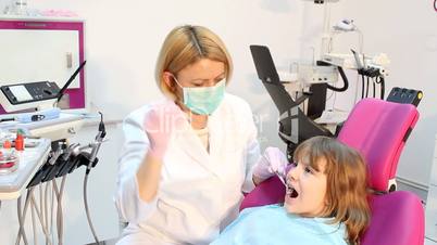 little girl with drilling treatment at the female dentist