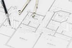 Engineer Pencil and Compass Resting on House Plans