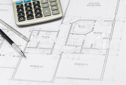 Pencil, Ruler and Calculator Resting on House Plans