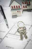Model Home, Pencil and Keys Resting On House Plans
