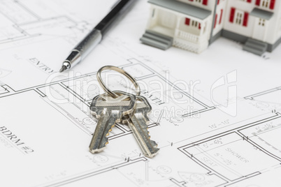 Model Home, Engineer Pencil and Keys Resting on House Plans