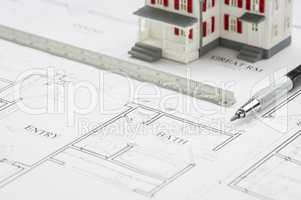 Model Home, Engineer Pencil and Ruler Resting On House Plans