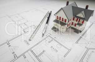Model Home, Engineer Pencil and Ruler Resting On House Plans