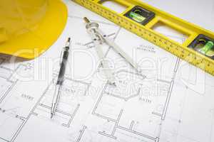 Hard Hat, Pencil, Level and Compass Resting on House Plans