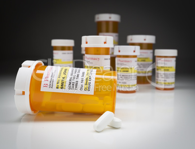 Medicine Bottles and Pills on Reflective Surface With Grey Backg