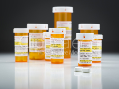 Medicine Bottles and Pills on Reflective Surface With Grey Backg